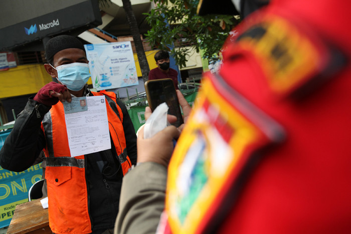 Warga terjaring razia masker yang diadakan petugas Satpol PP di kawasan Tanjung Duren, Jakarta, Jumat (11/6/2021).