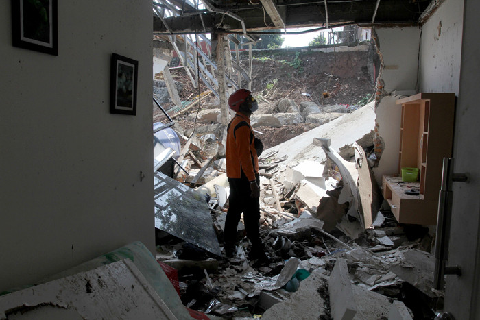 Pemilik rumah melihat rumahnya yang hancur tertimpa tanah longsor di Perumahan Nerada Estate Ciputat, Tangerang Selatan, Banten, Sabtu (12/6/2021).