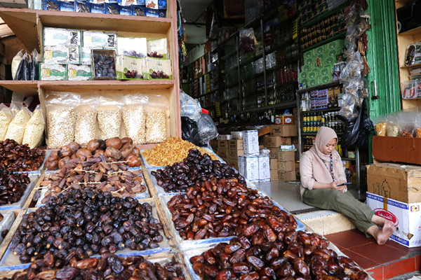 Pedagang menunggu pembeli di gerai oleh-oleh Haji dan Umroh di kawasan Pasar Tanah Abang, Jakarta, Minggu (13/6/2021).