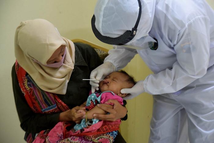 Sejumlah orang tua dan anaknya saat mengikuti screening berupa rapid test antigen di RS Bhayangkara Polda Jateng, Semarang, Jawa Tengah, Senin (14/6/2021).