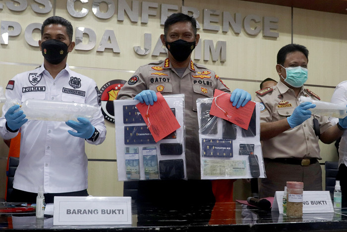 Polisi memamerkan barang bukti serta tersangka penyelundup benih lobster (benur) di Polda Jawa Timur, Selasa (15/6/2021).