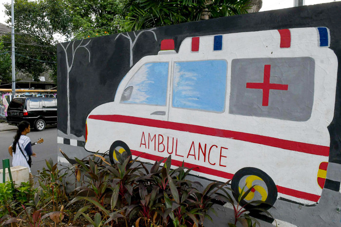 Petugas dan warga saat melintas di depan mural himbauan pandemi Covid-19 di Jakarta Selatan, Selasa (15/6/2021).