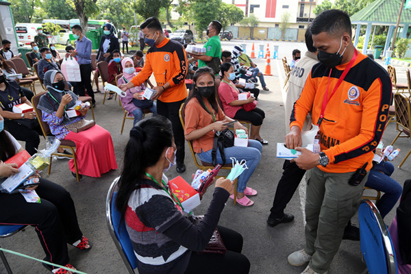 Penyerahan bantuan kepada Pekerja Migran Indonesia yang menjalani karantina di Asrama Haji Sukolilo Surabaya, Rabu (16/6/2021).