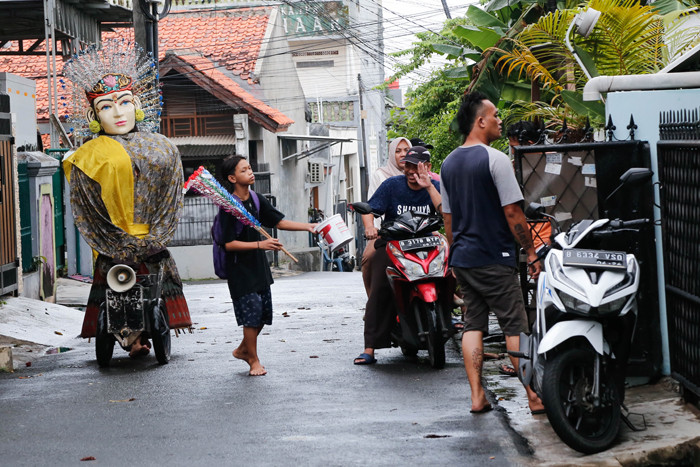 Kelompok pengarak Ondel-ondel tampak keluar dari pemukiman padat di kawasan Kramat Pulo, Jakarta Pusat.