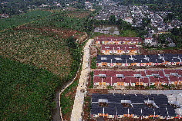 Pekerja beraktivitas di proyek pembangunan rumah bersubsidi di Kabupaten Bogor, Jawa Barat, Selasa (15/6/2021).