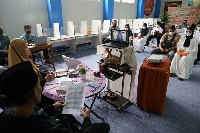 Siswa dan Munaqis menyimak hafalan Alquran secara virtual dalam Munaqosah Hafalan Al-Quran di SMP Al-Falah Deltasari Sidoarjo, Jawa Timur, Kamis (17/6/2021).