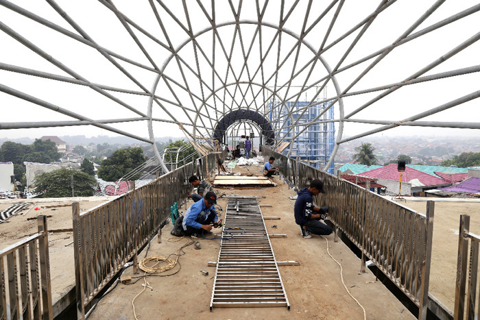 Sejumlah pekerja menyelesaikan proyek pembangunan jembatan penyeberangan orang di Jalan Raya Lenteng Agung, Jagakarsa, Jakarta Selatan, Kamis, (17/6/2021).