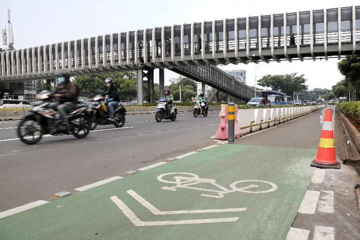 Pesepeda melintasi jalur sepeda permanen di kawasan Jalan Sudirman, Jakarta Pusat, Jumat (18/6/2021).