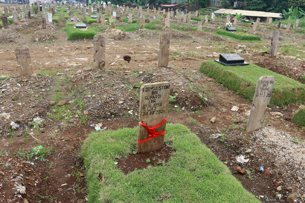 Sebuah papan nisan diberi kain penanda di TPU Srengseng Sawah, Jakarta Selatan, Jumat (18/6/2021).