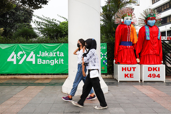 Pengunjung saat berfoto didepan ondel-ondel yang terpajang di kawasan Jalan Jenderal Sudirman, Jakarta Pusat, Minggu (20/6/2021).