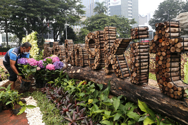 Petugas Suku Dinas Kehutanan DKI Jakarta menyelesaikan hiasan bertuliskan Jakarta Bangkit di kawasan Patung Kuda, Jakarta, Minggu (20/6/2021).