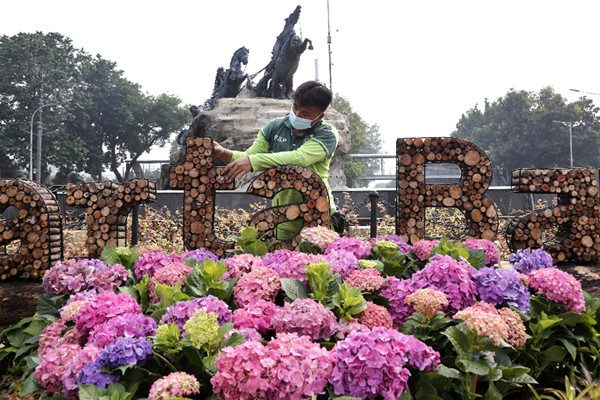 Petugas Suku Dinas Kehutanan DKI Jakarta menyelesaikan hiasan bertuliskan Jakarta Bangkit di kawasan Patung Kuda, Jakarta, Minggu (20/6/2021).
