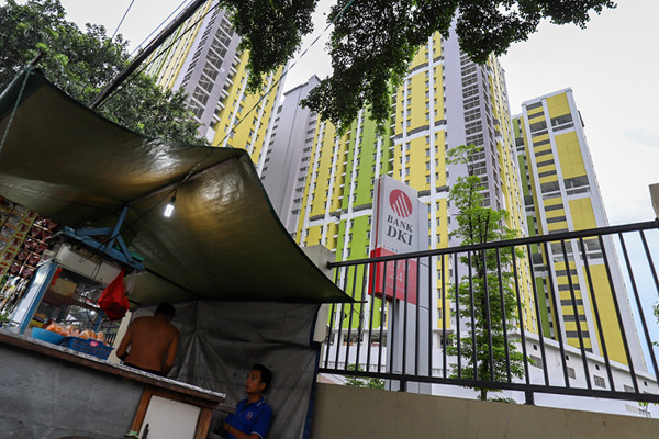 Warga saat melintas didepan Rumah Susun Pasar Rumput, Manggarai, Jakarta Selatan, Minggu (20/6/2021).