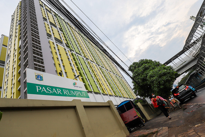 Warga saat melintas didepan Rumah Susun Pasar Rumput, Manggarai, Jakarta Selatan, Minggu (20/6/2021).