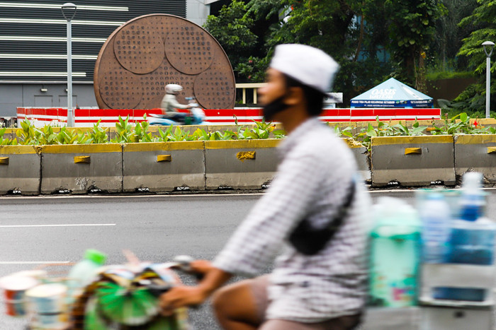 Pesepeda melintas didepan tugu sepeda yang sampai saat ini belum rampung akibat polemik yang terjadi di Jalan Jenderal Sudirman, Jakarta, Minggu (20/6/2021).