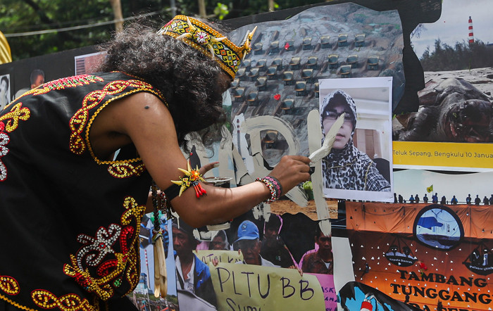 Demonstran melakukan aksi teatrikal menolak revisi UU Minerba di kawasan Bundaran Patung Kuda Arjuna Wijaya, Jakarta, Senin (21/6/2021).