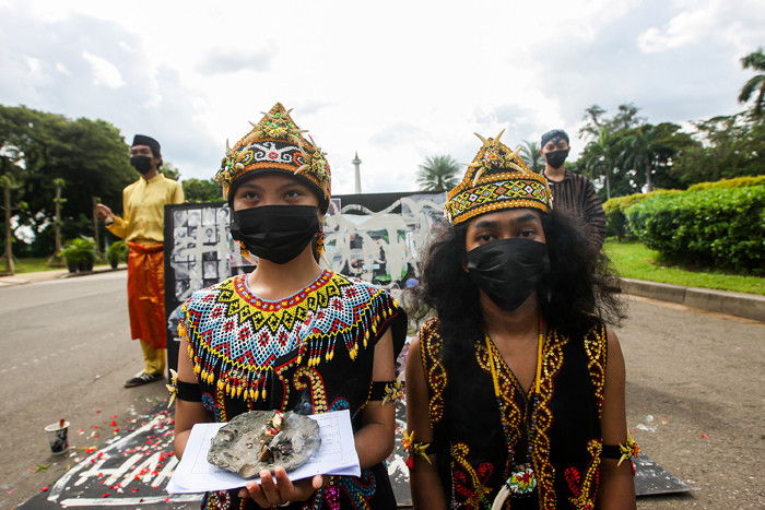 Demonstran melakukan aksi teatrikal menolak revisi UU Minerba di kawasan Bundaran Patung Kuda Arjuna Wijaya, Jakarta, Senin (21/6/2021).