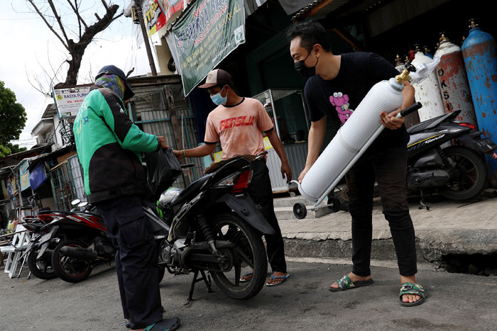 Warga mengantre untuk mengisi tabung oksigen medis di kawasan Manggarai, Jakarta, Senin (21/6/2021).