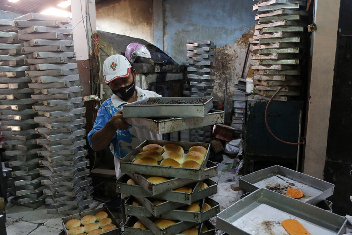 Pekerja menyelesaikan pembuatan roti skala rumahan di kawasan Bendungan Hilir, Jakarta, Senin (21/6/2021).