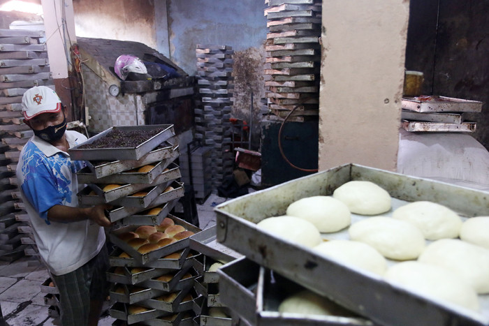 Pekerja menyelesaikan pembuatan roti skala rumahan di kawasan Bendungan Hilir, Jakarta, Senin (21/6/2021).