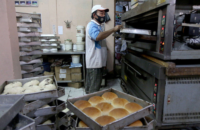 Pekerja menyelesaikan pembuatan roti skala rumahan di kawasan Bendungan Hilir, Jakarta, Senin (21/6/2021).