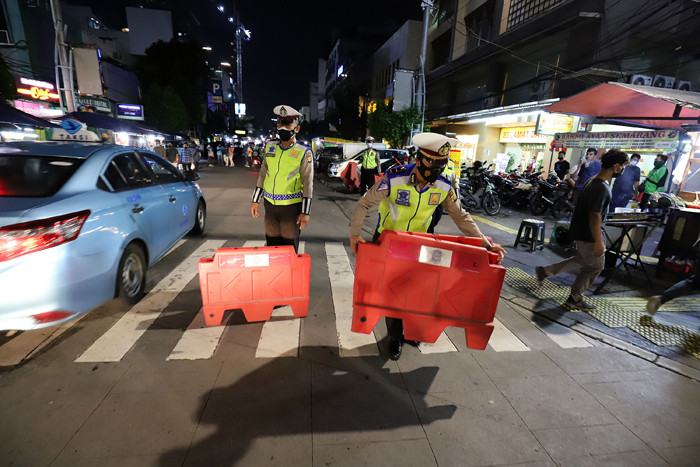 Petugas kepolisian menyusun pembatas jalan saat akan melakukan penutupan jalan di kawasan Sabang, Jakarta, Senin (21/6/2021).