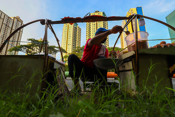 Pedagang sedang membuat kerak telor makanan khas Betawi yang masih bertahan dimasa pandemi di kawasan Kemayoran, Jakarta Pusat, Selasa (22/6/2021).