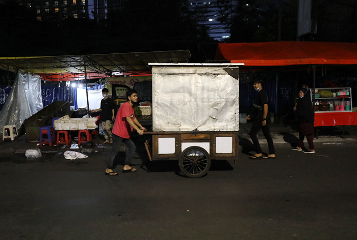Pedagang merapikan daganganya saat jam pembatasan kegiatan masyarakat di kawasan Sabang, Jakarta, Senin (21/6/2021).