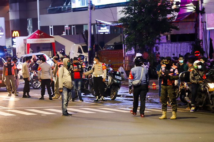 Petugas gabungan menutup akses menuju Jalan Asia Afrika, Jakarta Pusat, Senin (21/6/2021).