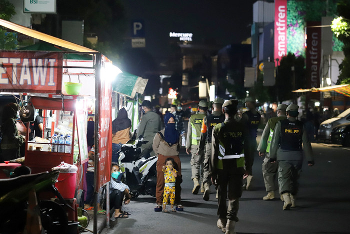 Petugas Satpol PP membubarkan aktivitas pedagang kaki lima dalam rangka pembatasan mobilitas di kawasan Sabang, Jakarta, Senin (21/6/2021).