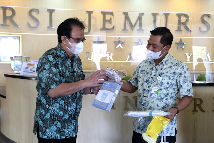 Kepala BP Jamsostek Surabaya Rungkut Rudi Susanto (kanan) menyerahkan bantuan APD Covid-19 lengkap di RSI Jemursari Surabaya, Jawa Timur, Rabu (23/6/2021).