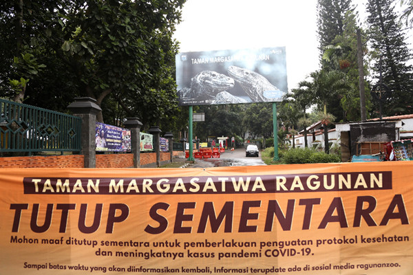Spanduk bertuliskan 'Tutup Sementara' terpasang di gerbang masuk Taman Margasatwa Ragunan, Rabu (23/6/2021).