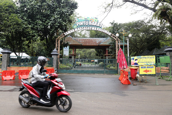Spanduk bertuliskan 'Tutup Sementara' terpasang di gerbang masuk Taman Margasatwa Ragunan, Rabu (23/6/2021).