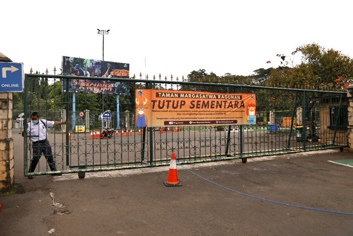 Spanduk bertuliskan 'Tutup Sementara' terpasang di gerbang masuk Taman Margasatwa Ragunan, Rabu (23/6/2021).