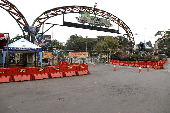 Spanduk bertuliskan 'Tutup Sementara' terpasang di gerbang masuk Taman Margasatwa Ragunan, Rabu (23/6/2021).