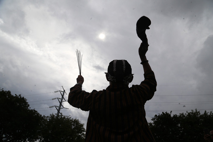 Pawang hujan asal Surabaya Mbah Purnomo atau Mbah Ghofur melakukan ritual di Lapangan Prapat Kurung, Surabaya, Jawa Timur, Kamis (24/6/2021).