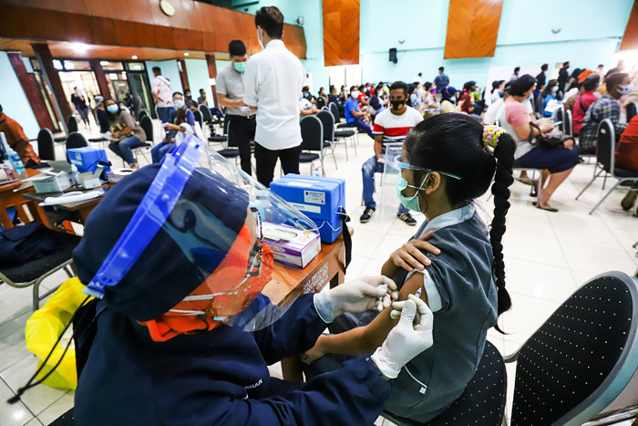 Warga saat mengikuti vaksinasi Covid-19 dengan target vaksinasi 1 juta dosis per hari di GOR Jakarta Barat, Jumat (25/6/2021).