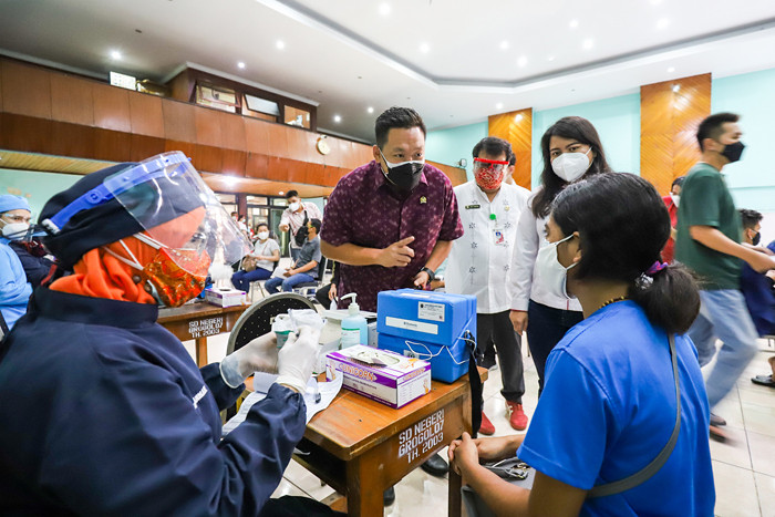 Warga saat mengikuti vaksinasi Covid-19 dengan target vaksinasi 1 juta dosis per hari di GOR Jakarta Barat, Jumat (25/6/2021).