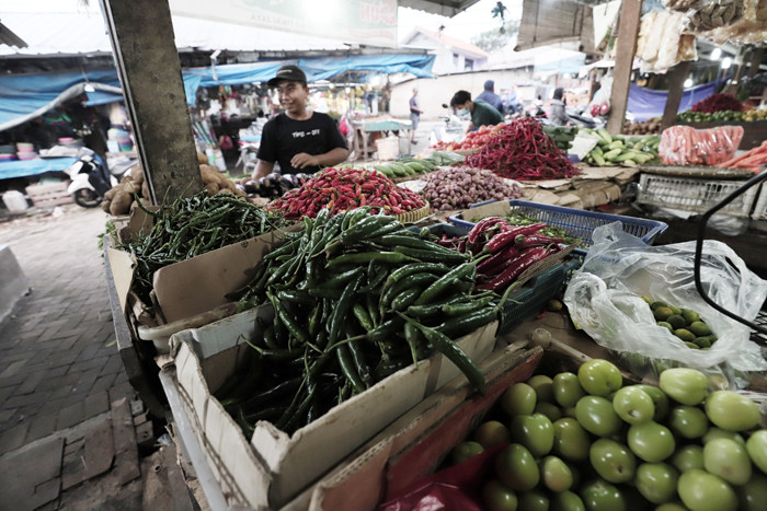 Pedagang merapikan dagangannya di Pasar Kecapi, Kota Bekasi, Jawa Barat, Jumat (25/6/2021).