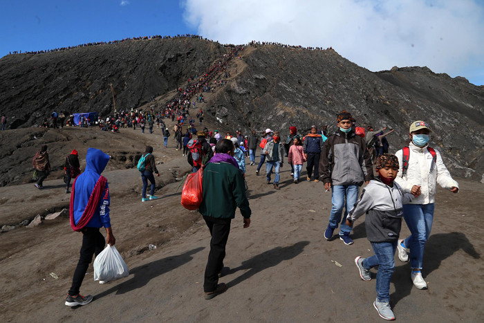 Warga Tengger menanti matahari terbit di bibir kawah Gunung Bromo pada perayaan Yadnya Kasada tahun ke 1943 Saka di Probolinggo, Jawa Timur, Sabtu (26/6/2021).