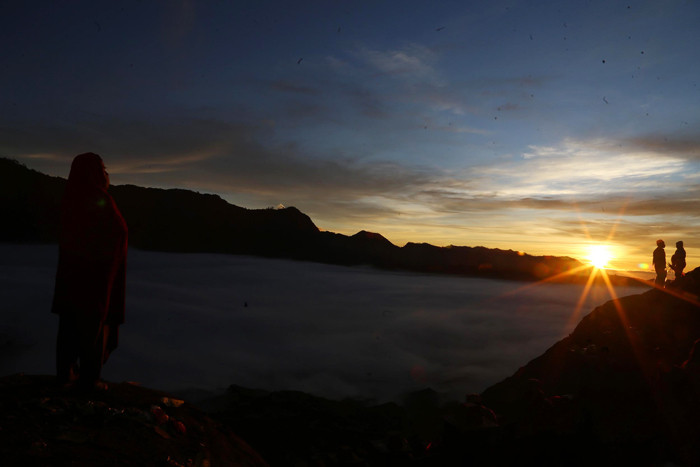 Warga Tengger menanti matahari terbit di bibir kawah Gunung Bromo pada perayaan Yadnya Kasada tahun ke 1943 Saka di Probolinggo, Jawa Timur, Sabtu (26/6/2021).