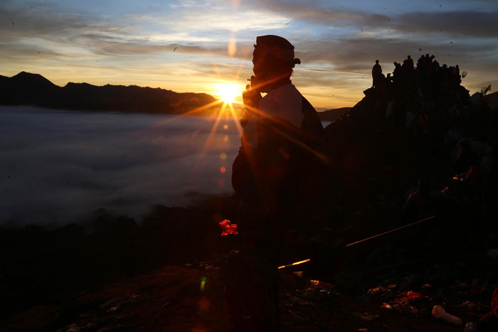 Warga Tengger menanti matahari terbit di bibir kawah Gunung Bromo pada perayaan Yadnya Kasada tahun ke 1943 Saka di Probolinggo, Jawa Timur, Sabtu (26/6/2021).