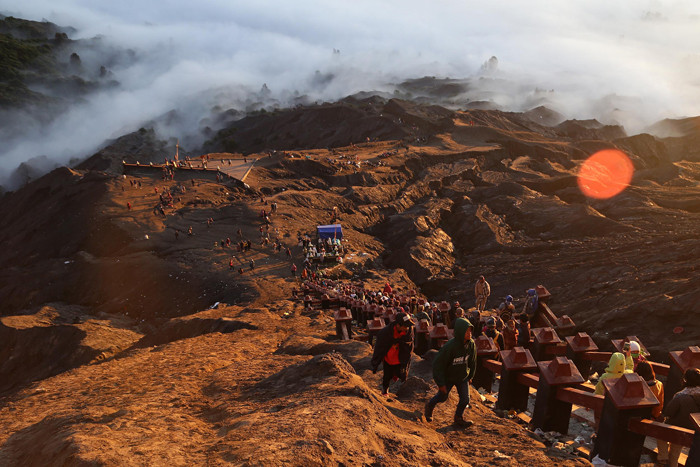 Warga Tengger menanti matahari terbit di bibir kawah Gunung Bromo pada perayaan Yadnya Kasada tahun ke 1943 Saka di Probolinggo, Jawa Timur, Sabtu (26/6/2021).