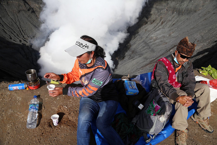 Warga Tengger menanti matahari terbit di bibir kawah Gunung Bromo pada perayaan Yadnya Kasada tahun ke 1943 Saka di Probolinggo, Jawa Timur, Sabtu (26/6/2021).