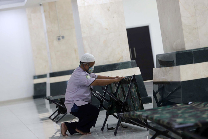 Petugas membersihkan ruangan yang akan dijadikan tempat isolasi pasien Covid-19 di Masjid Raya KH Hasyim Asyari, Jakarta, Sabtu (26/6/2021).