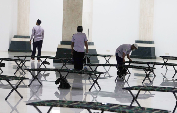 Petugas membersihkan ruangan yang akan dijadikan tempat isolasi pasien Covid-19 di Masjid Raya KH Hasyim Asyari, Jakarta, Sabtu (26/6/2021).
