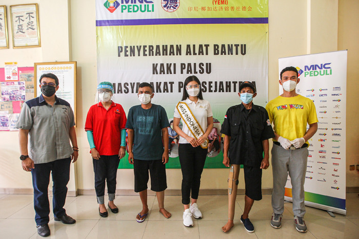Miss Indonesia 2020 Pricilia Carla Yules membantu petugas memasang kaki palsu di Yayasan Etika Moral Indonesia, Jakarta, Minggu (27/6/2021).
