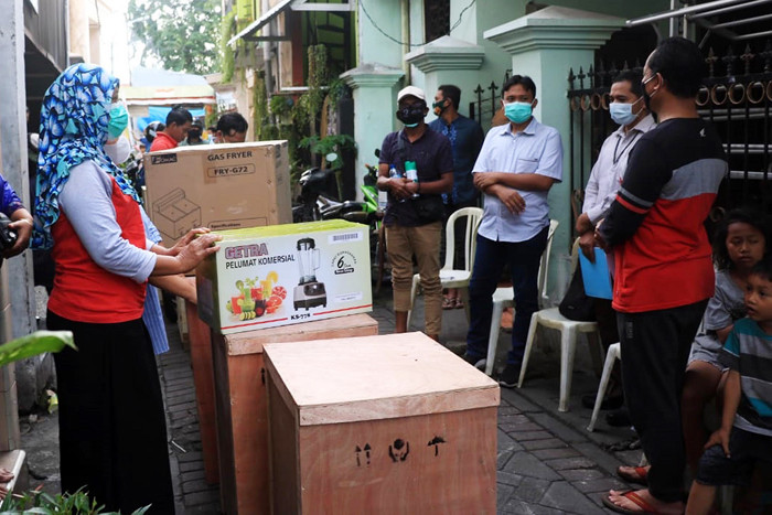 Para pelaku usaha jajanan pasar memeriksa sejumlah peralatan produksi saat serahterima di Tegalsari Surabaya, Jawa Timur, Senin (28/6/2021).
