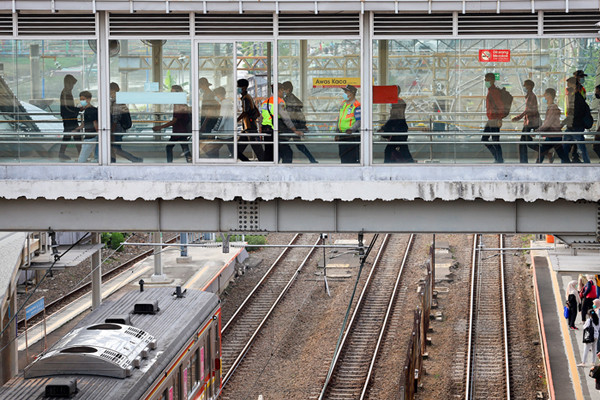 Calon penumpang berjalan menuju rangkaian kereta rel listrik (KRL) di Stasiun Tanah Abang, Jakarta Pusat, Senin (28/6/2021).