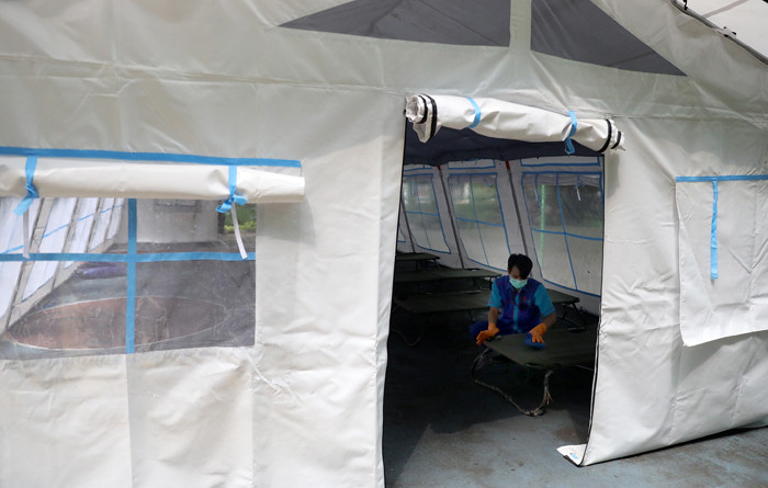 Pekerja RSUD Tarakan menyiapkan velbed di tenda darurat di SDN Negeri 02 Cideng, Jakarta, Selasa (29/6/2021).